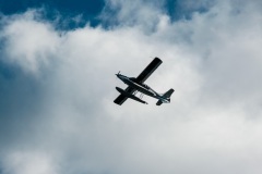 A amphibious plane against white clouds after taking off from Lake Union