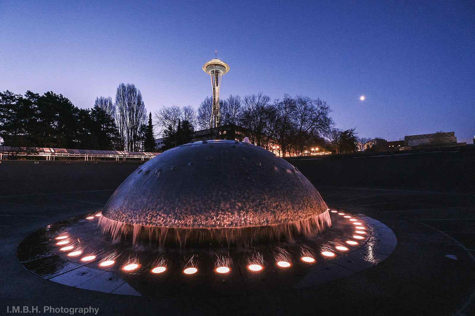 Seattle Space Needle against a twilit morning sky seen from the Internaional Fountain in Seattle Center Seattle Space Needle against a twilit morning sky seen from the Internaional Fountain in Seattle Center