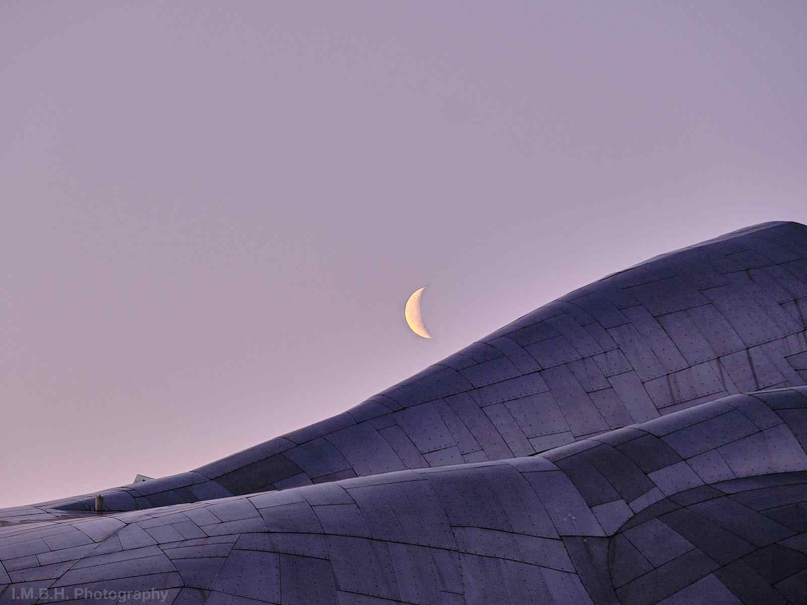 Waning crescent moon over the MoPop Museum in Seattle