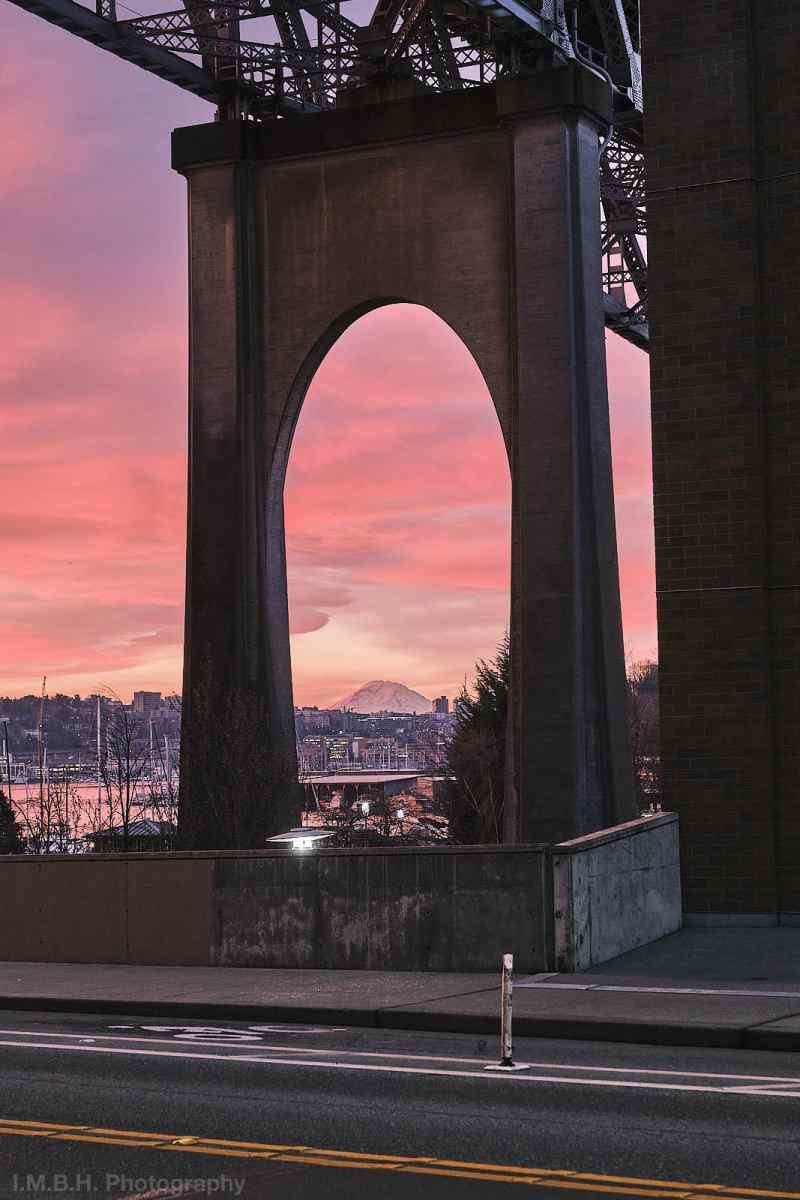 Mt Rainier with pink sunrise clouds seen under the Aurora Avenue Bridge