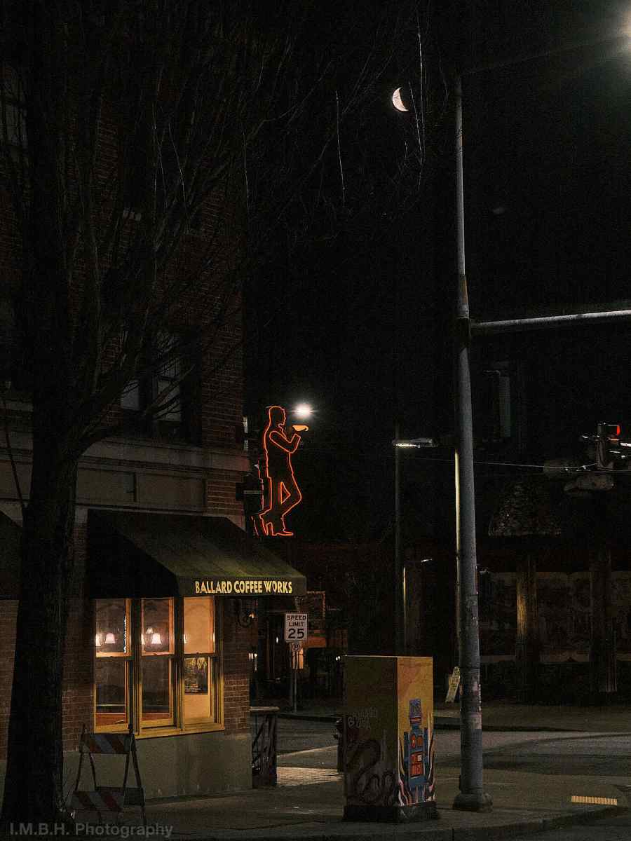 Neon figure holding a coffee mug in downtown Ballard
