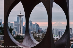The Space Needle and Mt Rainier seen through the sculpture Changing Form by Dori Totten