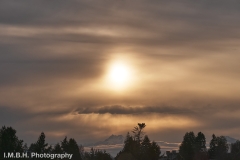 Golden sunset through clouds, over the Olympic Mountains