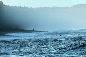 Person standing alone on a beach, 